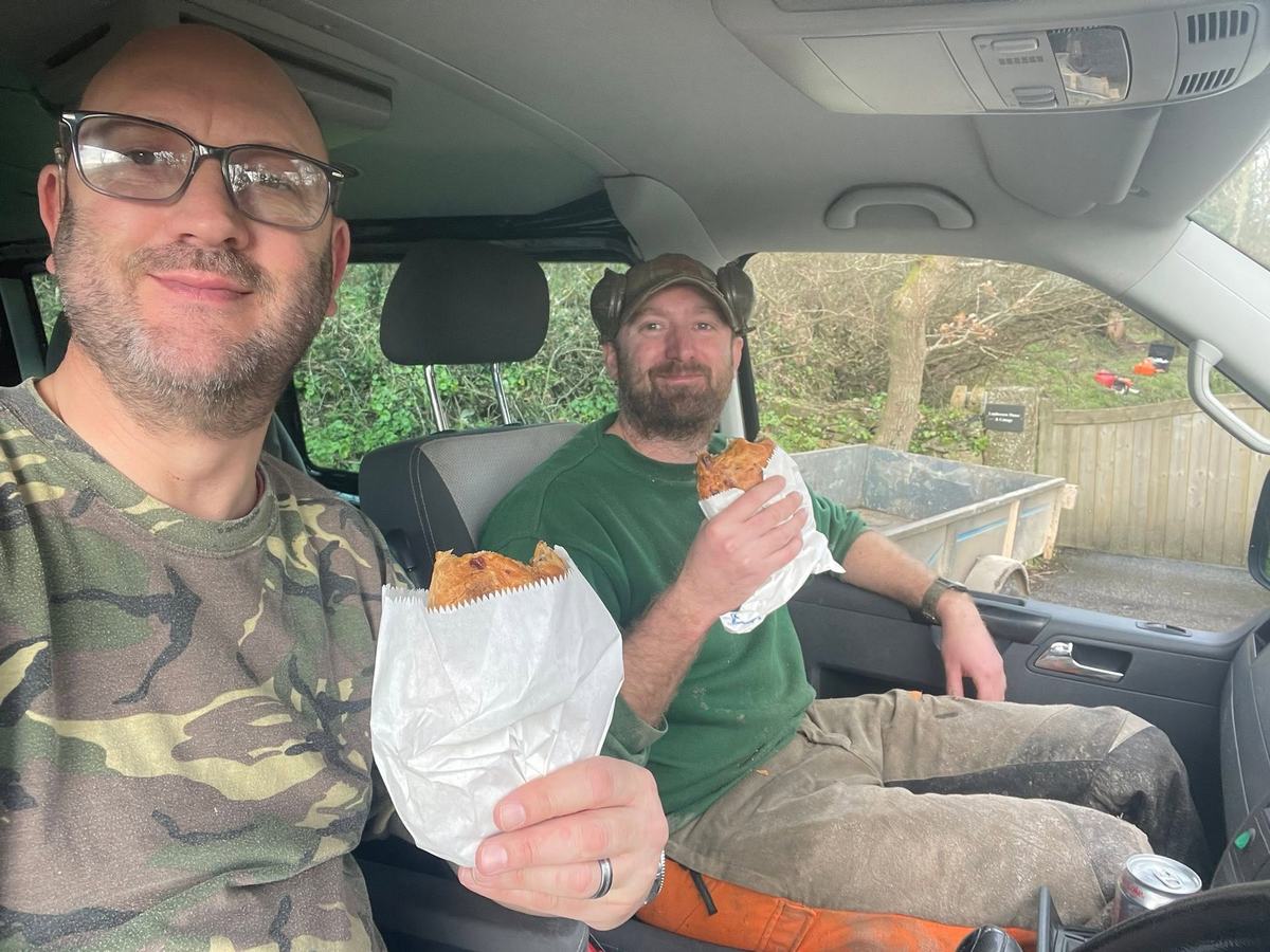 Peter and Jon in the van, each holding a pasty