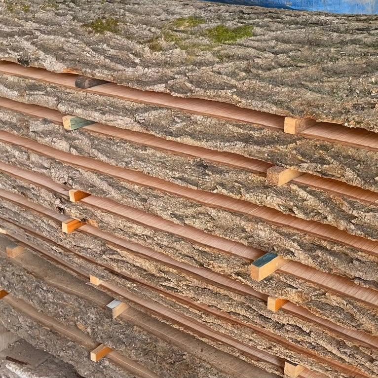 Bark-edged boards stacked and stickered to air-dry