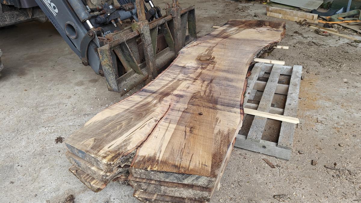 A stack of freshly milled live-edge slabs