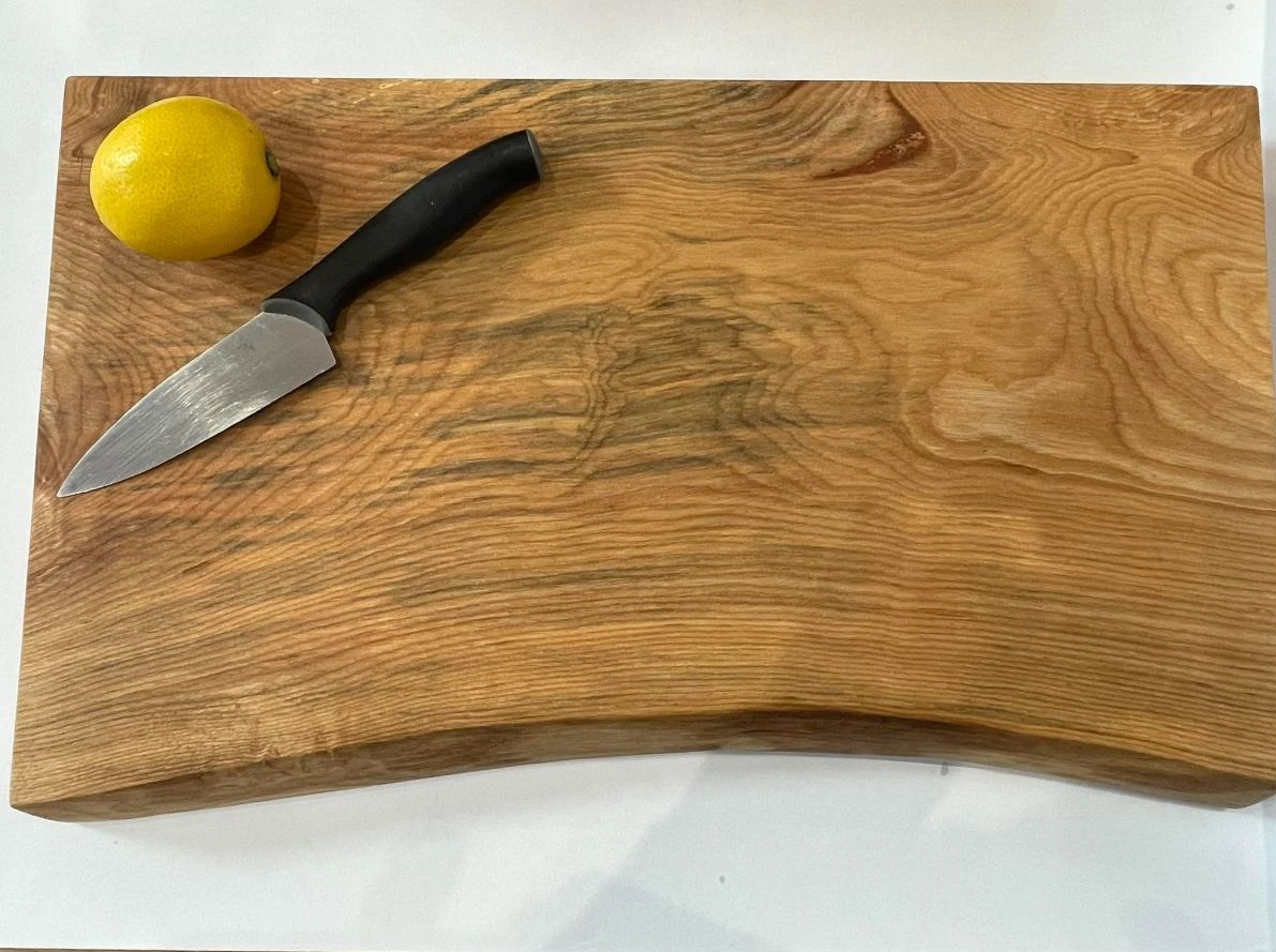 A sweet chestnut chopping board with a knife and a lemon