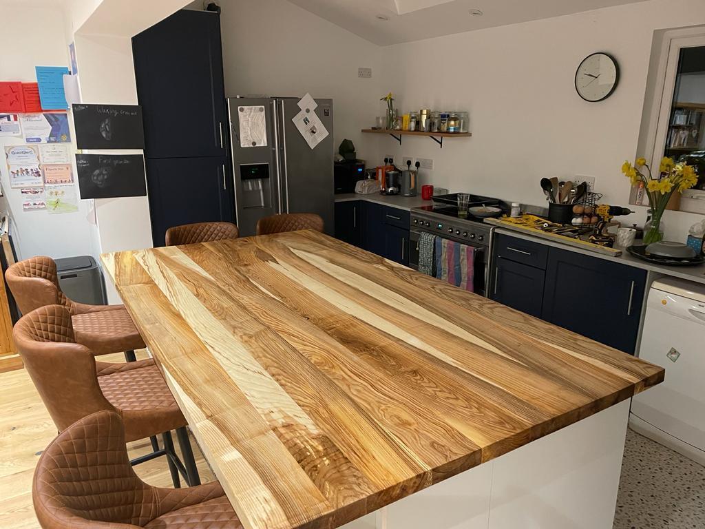 A kitchen island with a figured timber worktop